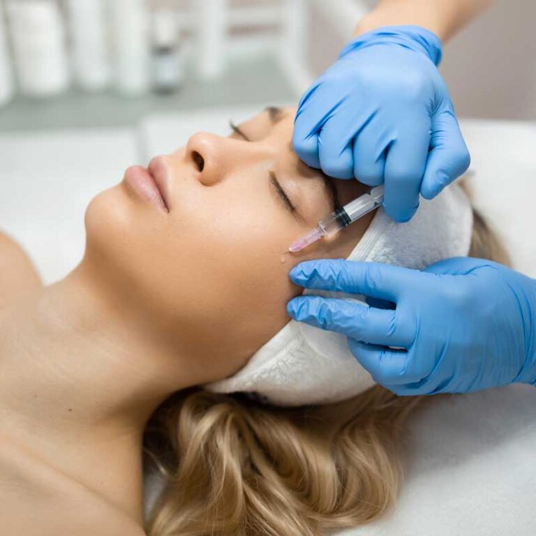 Practitioner injecting dermal filler into a patients upper cheek